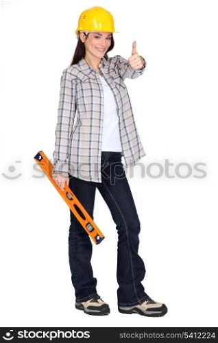 Woman holding spirit-level and giving the thumbs-up
