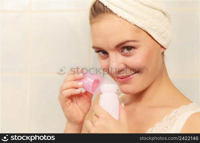 Woman holding stick deodorant in hands. Girl in bathroom towel on head with antiperspirant cosmetics. Daily skin care and hygiene.. Woman holds stick deodorant cosmetic in hands