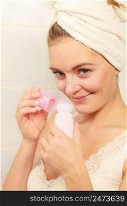 Woman holding stick deodorant in hands. Girl in bathroom towel on head with antiperspirant cosmetics. Daily skin care and hygiene.. Woman holds stick deodorant cosmetic in hands