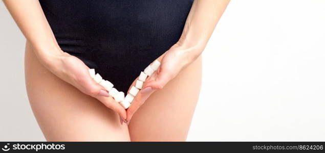 Woman holding sugar cubes on bikini zone, the concept of intimate depilation, problems of intimate hygiene. Woman holding sugar cubes on bikini zone, the concept of intimate depilation, problems of intimate hygiene.