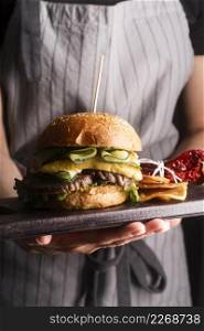 woman holding tasty meal with hamburger