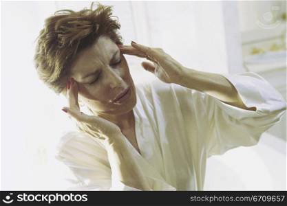 Woman holding the side of her head in pain