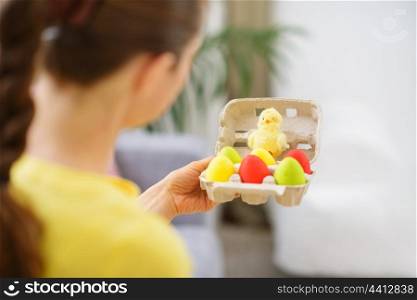 Woman holding tray with colorful Easter eggs and chicken