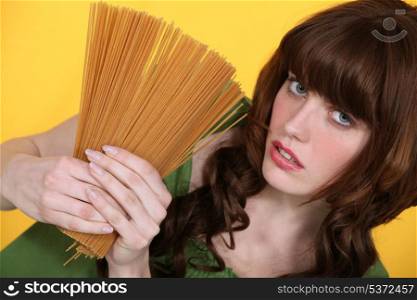 Woman holding uncooked spaghetti