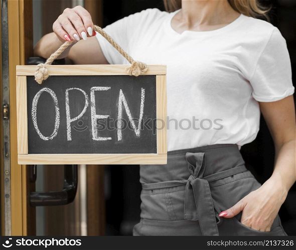 woman holding we are open sign
