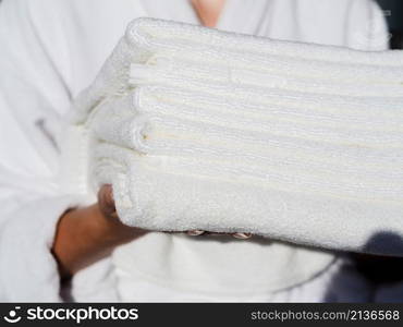 woman holding white folded clean towels