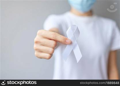 Woman holding white Ribbon for November Lung Cancer Awareness month, democracy and international peace day. Healthcare concept