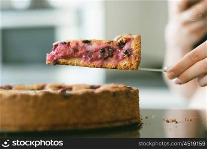 Woman holding wild berry homemade pie slice with raspberries and blueberries. Shallow depth of field.