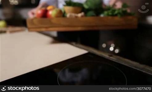 Woman holding wooden tray with fruits and vegetables and showing to camera closeup. Set of fresh raw organic food ingredients in tray for cooking vegan smoothie. Healthy eating and dieting concept.