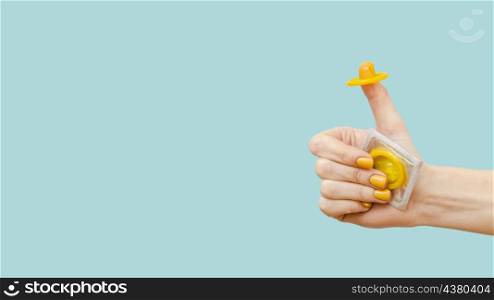 woman holding yellow condom her finger