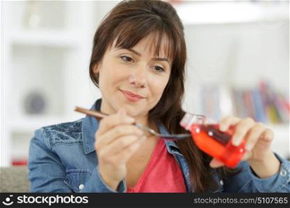 woman holds a spoon with syrup