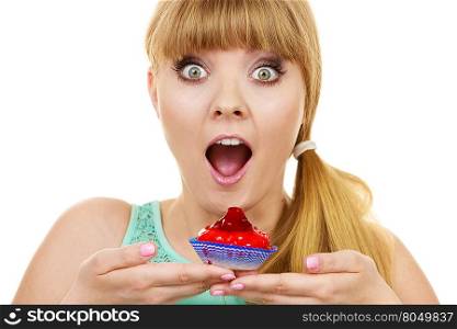 Woman holds cake strawberry cupcake . Woman wide open mouth holds cake cupcake in hand unhealthy food snack. Bakery sweet eating happiness and people concept.