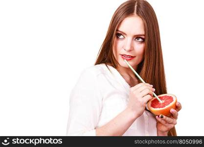 Woman holds grapefruit drinking juice from fruit. Woman attractive long hair girl colorful eyes makeup holding grapefruit citrus drinking juice from fruit. Healthy diet food. Summer vacation holidays concept. Copy space for text