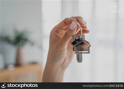 Woman holds house keys, symbolizing new home. Real estate agent offers apartments for sale or rent. Mortgage advertisement.