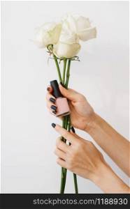 Woman holds nail varnish and flowers, beauty salon, manicure and pedicure procedure. Professional beautician service, female customer, toenail and fingernail care in spa studio. Woman holds nail varnish and flowers, beauty salon
