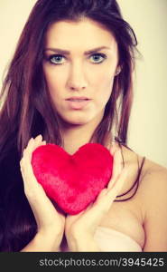 Woman holds red heart love symbol. Woman long hair young female holding red heart love symbol studio shot on bright. Valentines day happiness concept. Filtered photo