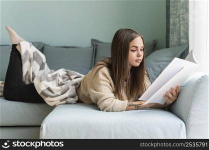 woman home couch reading book during pandemic