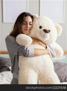 woman home embracing big teddy bear