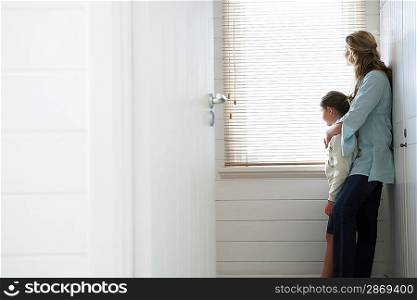 Woman Hugging Daughter By Window
