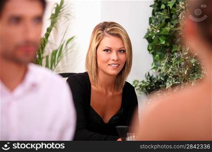 Woman in a black dress sitting in a restaurant