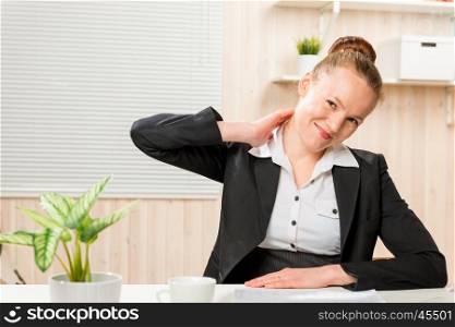 woman in a business suit rubbing his neck, which is sore from working at a computer