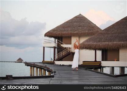 woman in a dress on a bridge home sea
