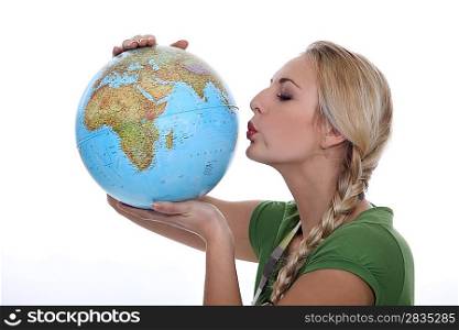 Woman in a green top kissing a globe