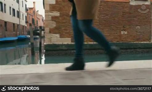 Woman in a hurry in the street of Venice. Female feet walking fast and then starting to run