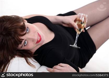 Woman in a little black dress with a glass of champagne