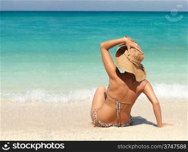 Woman in a straw hat enjoying a tropical beach