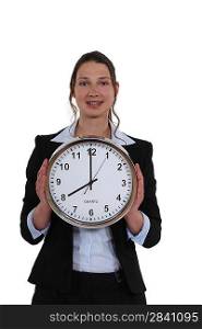 woman in a suit holding a huge clock