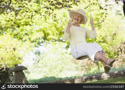 Woman in a swing outdoors smiling