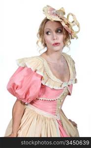 Woman in a theatrical pink and cream dress and bonnet