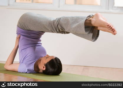 Woman in a traditional stretching yoga pose at home or gym