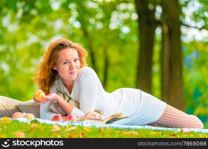 woman in a white dress on a picnic in the park with apples