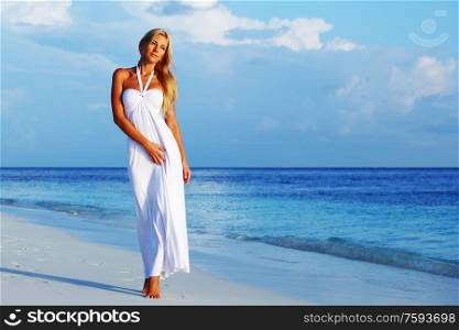 woman in a white dress on the ocean coast. woman on the ocean coast