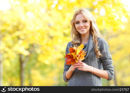 Woman in autumn forest. Portrait of a beautiful blond smiling woman in autumn forest