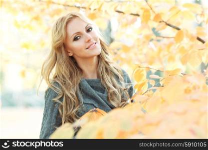 Woman in autumn park. Portrait of young woman in beautiful autumn park
