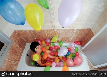 Woman in bath full of balloons