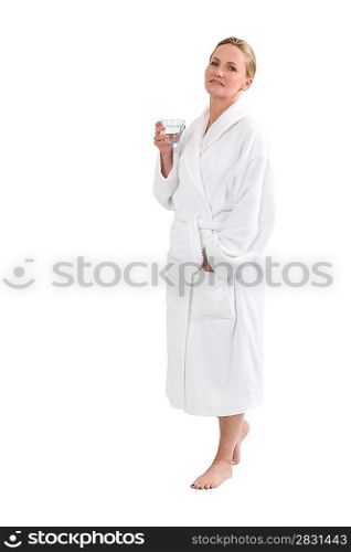 Woman in bath robe with a glass of water