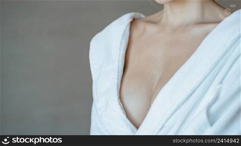 Woman in bathrobe, close up on chest.