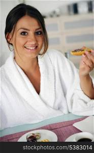 woman in bathrobe having breakfast