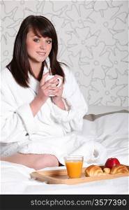 Woman in bathrobe with coffee in hand