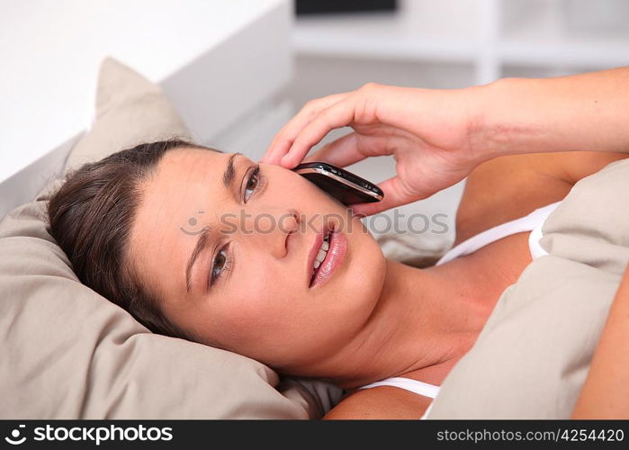 Woman in bed telephoning