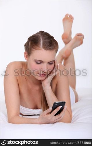 Woman in bed with a cellphone