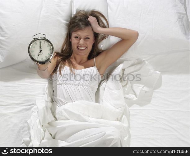 Woman in bed with alarm clock