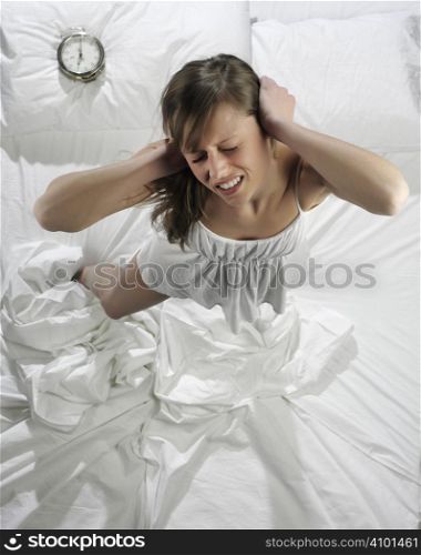 Woman in bed with alarm clock