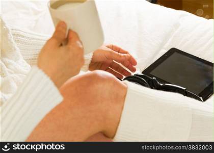 Woman in bed with her tablet with a cup of milk
