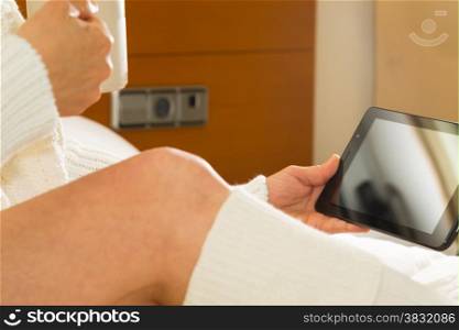 Woman in bed with her tablet with a cup of milk