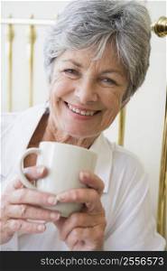 Woman in bedroom with coffee smiling
